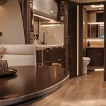 Camping car de luxe interieur : salon en bois et sellerie crème